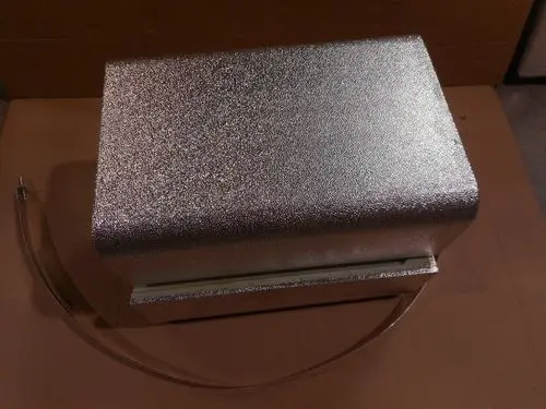 Silberne Isolierbox mit Textur und außen liegendem Anschlusskabel. Produkt von Remeha, geeignet für technische Anwendungen.